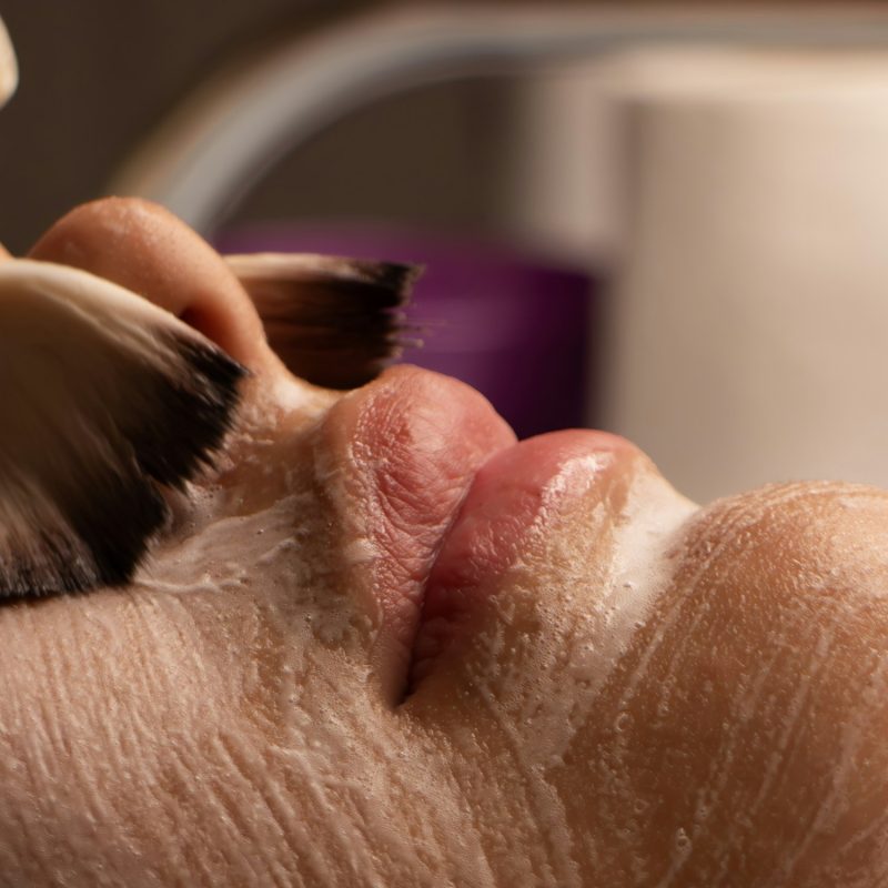 A clinician working treatment serum across the skin during a medical facial