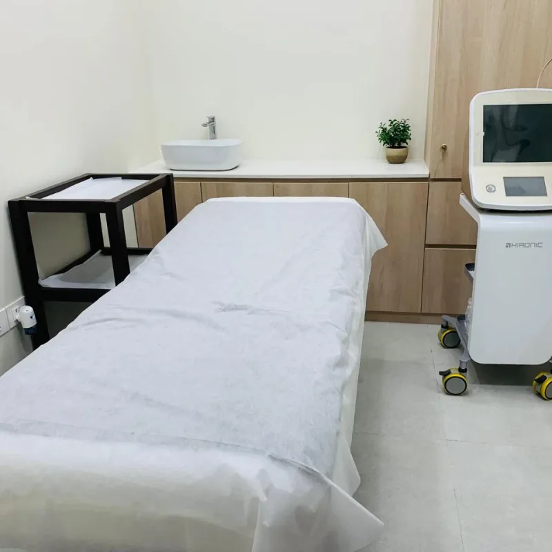 Treatment room at Veloura Clinic Gurgaon with a treatment bed, wash basin and Hironic device